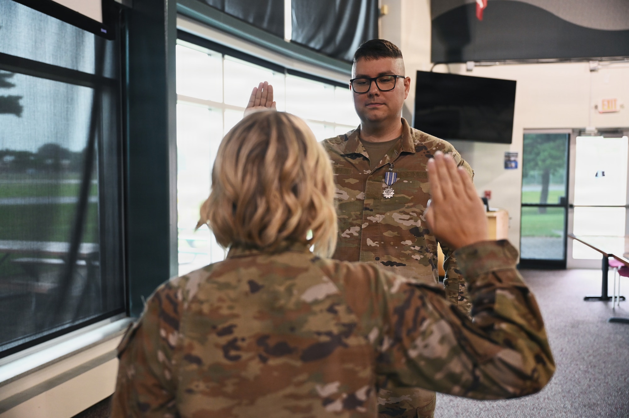 U.S. Air Force Lt. Col. Britney Hensley, commander of the 126th Intelligence Squadron, conducts the Oath of Enlistment for Tech. Sgt. Dylan Jacques, an intelligence analyst assigned to the 126th IS at Springfield-Beckley Air National Guard Base, who transferred to the 76th Intelligence, Surveillance and Reconnaissance Squadron in a historic ceremony June 26, 2026. This marks the first time an Airman in the Air National Guard has been authorized to transfer to the Space Force without completing their existing service commitments to the Guard. (U.S. Air National Guard photo by Shane Hughes)