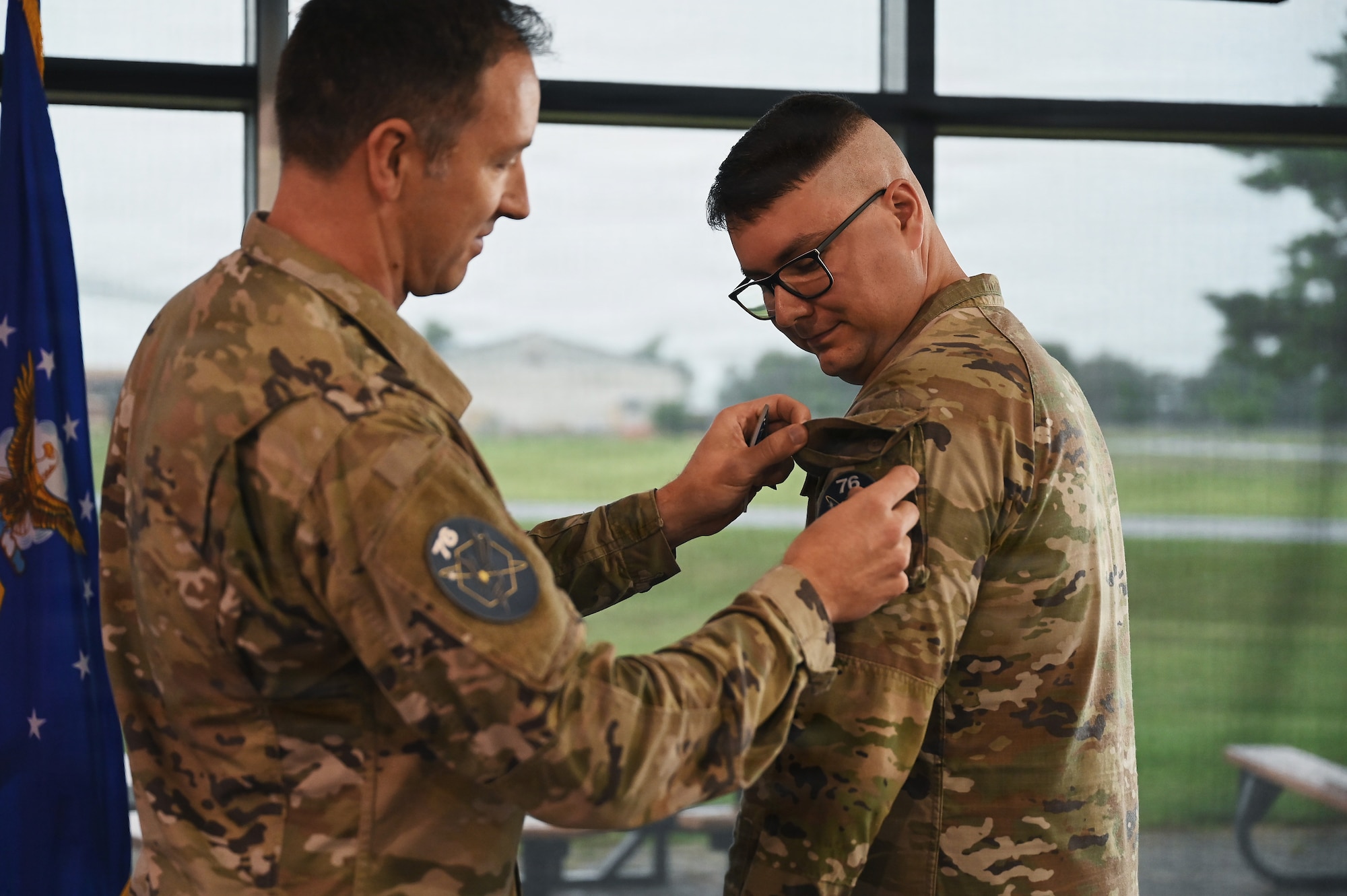 U.S. Space Force Lt. Col. Stefan Katz, commander of the 76th Intelligence, Surveillance and Reconnaissance Squadron places the 76th ISRS unit patch on Air Force Tech. Sgt. Dylan Jacques, an intelligence analyst assigned to the 126th Intelligence Squadron at Springfield-Beckley Air National Guard Base who transferred to the 76th ISRSin a historic ceremony June 26, 2026. This marks the first time an Airman in the Air National Guard has been authorized to transfer to the Space Force without completing their existing service commitments to the Guard. (U.S. Air National Guard photo by Shane Hughes)
