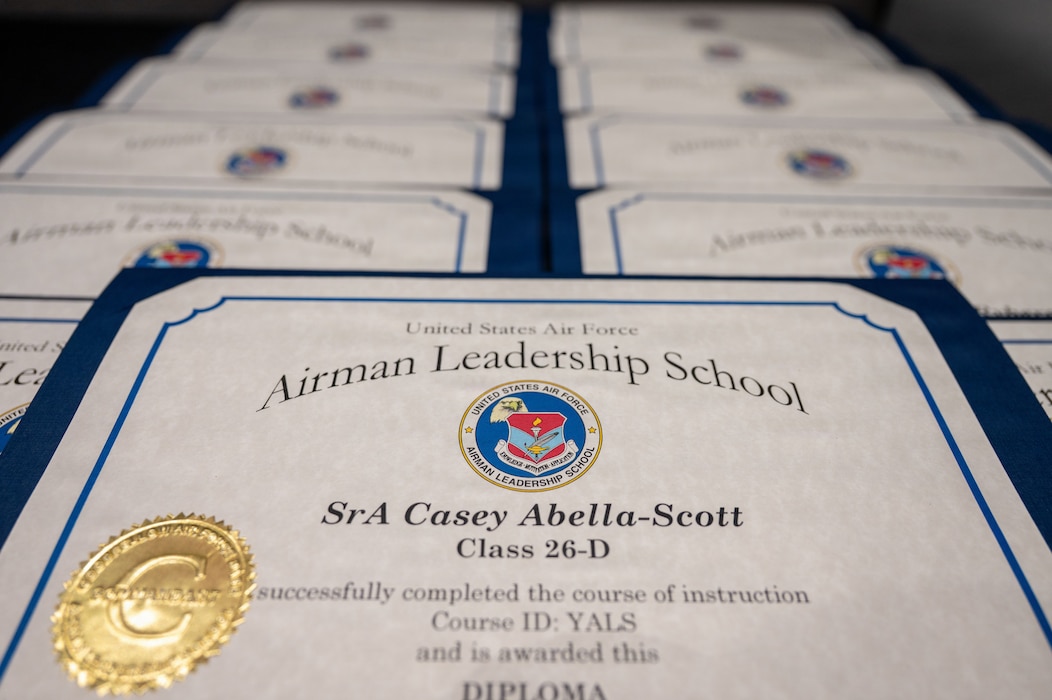 Certificates for an Airman Leadership School graduation are on a table