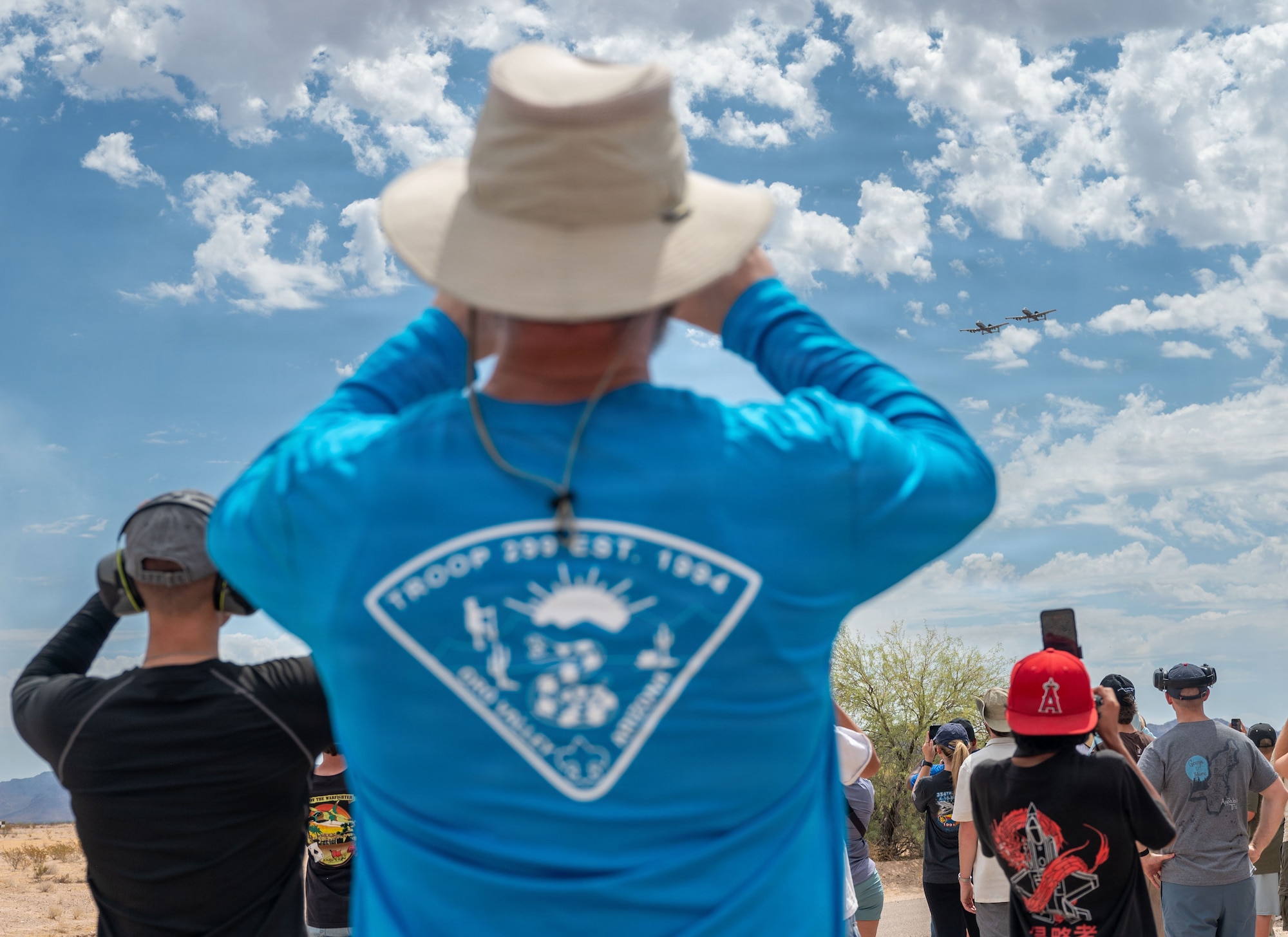 Attendees watch as two A-10C Thunderbolt II aircraft fly overhead in formation over the Barry M. Goldwater Range near Gila Bend, Arizona, June 25, 2026. Pilots displayed a show of air power for Davis-Monthan Air Force Base Airmen, community members and civic leaders during the final A-10 Range Day. U.S. Air Force photo by Airman Najzee Kuzu)