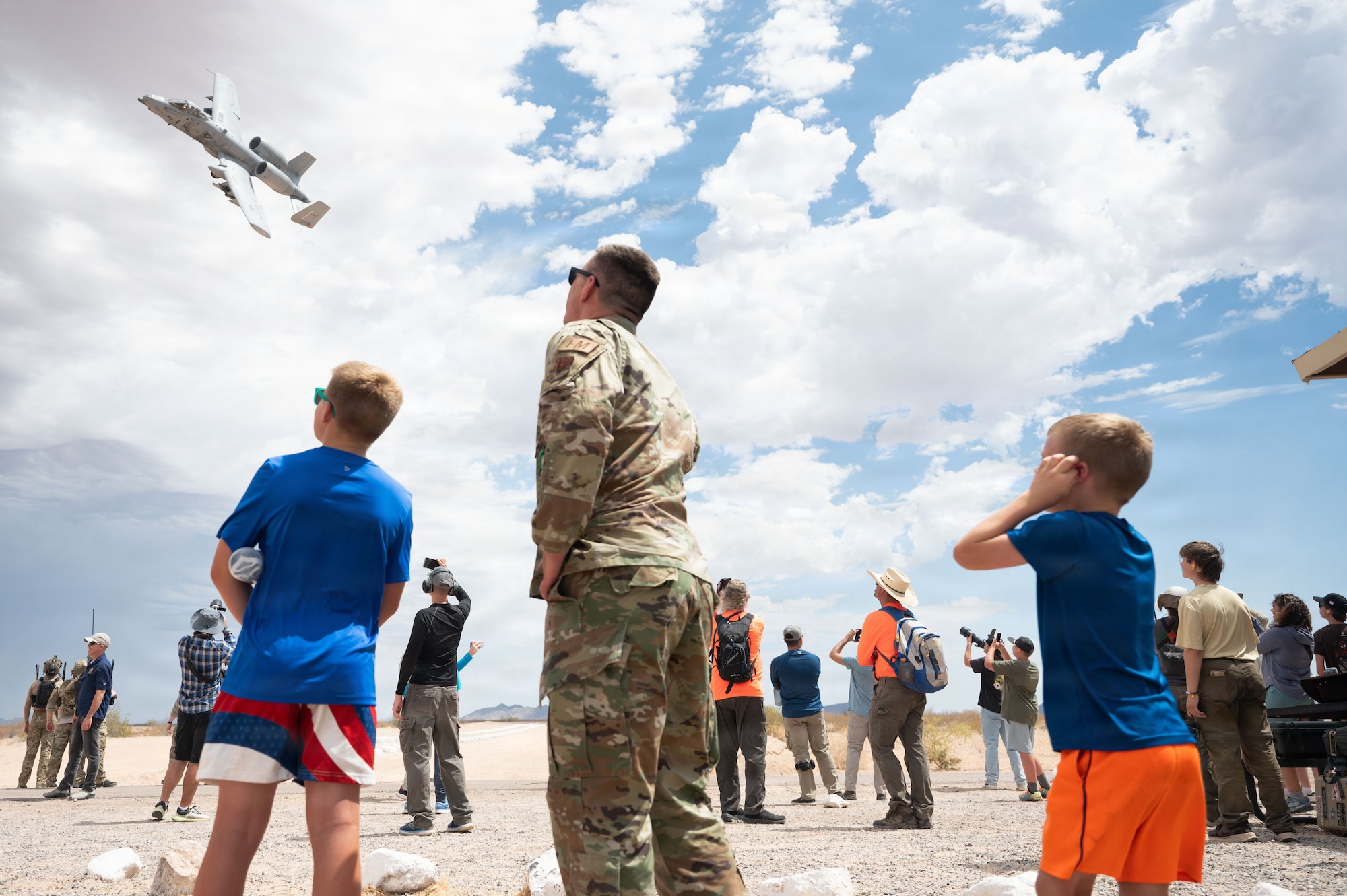 U.S. Air Force Lt. Col. Luke Kaspari, 355th Comptroller Squadron commander, watches with his family as an A-10C Thunderbolt II aircraft performs a show of force at the Barry M. Goldwater range near Gila Bend, Arizona, June 25, 2026. Over nearly five decades, DM's A-10 squadrons were deployed worldwide to provide close air support for ground troops in conflicts ranging from Operation Desert Storm to the wars in Iraq and Afghanistan. (U.S. Air Force photo by Airman Najzee Kuzu)