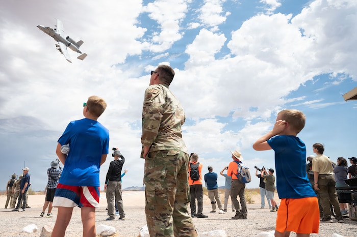 U.S. Air Force Lt. Col. Luke Kaspari, 355th Comptroller Squadron commander, watches with his family as an A-10C Thunderbolt II aircraft performs a show of force at the Barry M. Goldwater range near Gila Bend, Arizona, June 25, 2026. Over nearly five decades, DM's A-10 squadrons were deployed worldwide to provide close air support for ground troops in conflicts ranging from Operation Desert Storm to the wars in Iraq and Afghanistan. (U.S. Air Force photo by Airman Najzee Kuzu)
