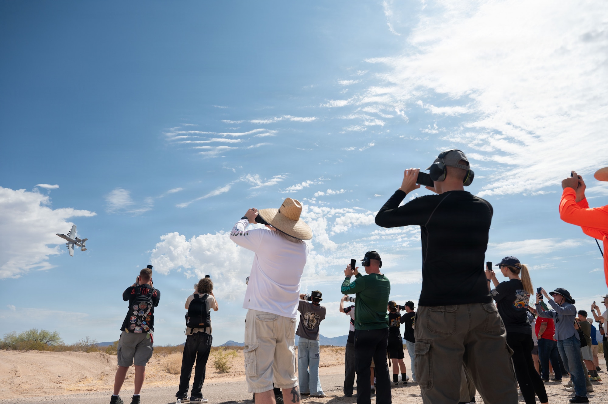 A-10 Range day attendees photograph an A-10C Thunderbolt II aircraft as the pilot performs a low pass at the Barry M. Goldwater Range near Gila Bend, Arizona, June 25, 2026. Davis-Monthan Air Force Base hosted Airmen, civic leaders, members of Scouting America and guests from The Southern Chamber of Arizona for what was the final A-10 Range Day for a display of air power. (U.S. Air Force photo by Airman Najzee Kuzu)