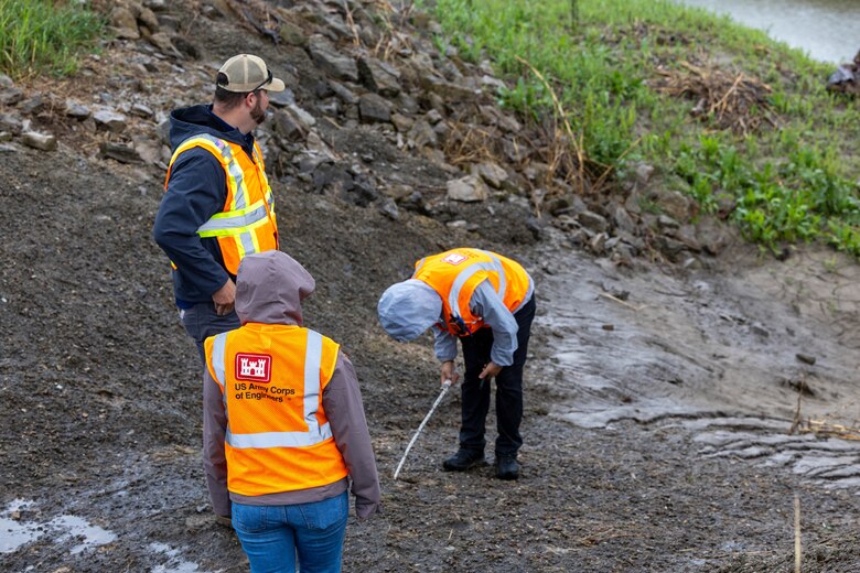 Man inspecting hole in channel.