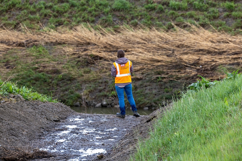 Woman looking at creek bank.