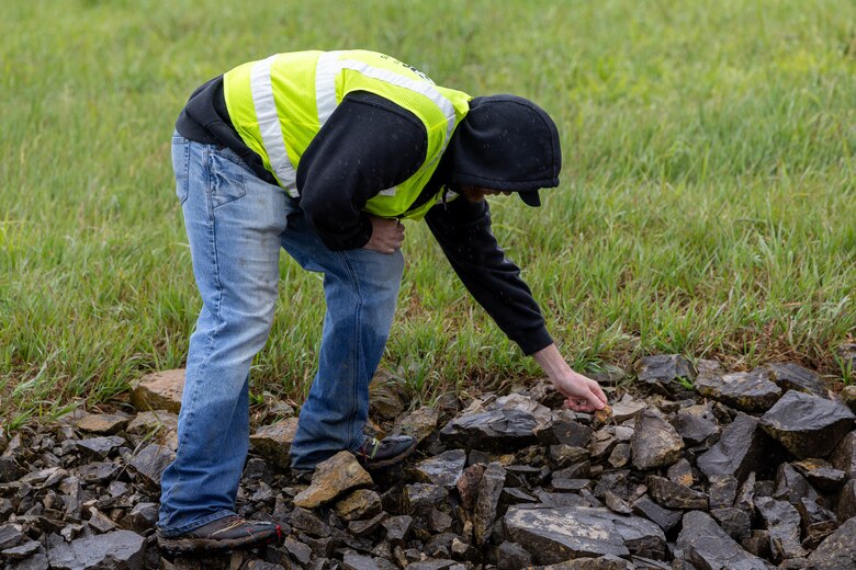 Man inspecting rock.