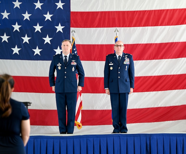 U.S. Air Force Col. Jimmy Schlabach, 91st Missile Wing commander (left), and U.S. Air Force Col. Joseph Edington 91st Maintenance Group (MXG) commander (right), stand at attention during the 91st MXG change of command ceremony at Minot Air Force Base, North Dakota, June 5, 2026. The 91st Maintenance Group ensures the readiness, reliability and sustainment of the wing's strategic weapon systems, providing safe, secure and effective support to the nation's nuclear deterrence mission. (U.S. Air Force photo by Airman Joseline Chacon Monterroso)