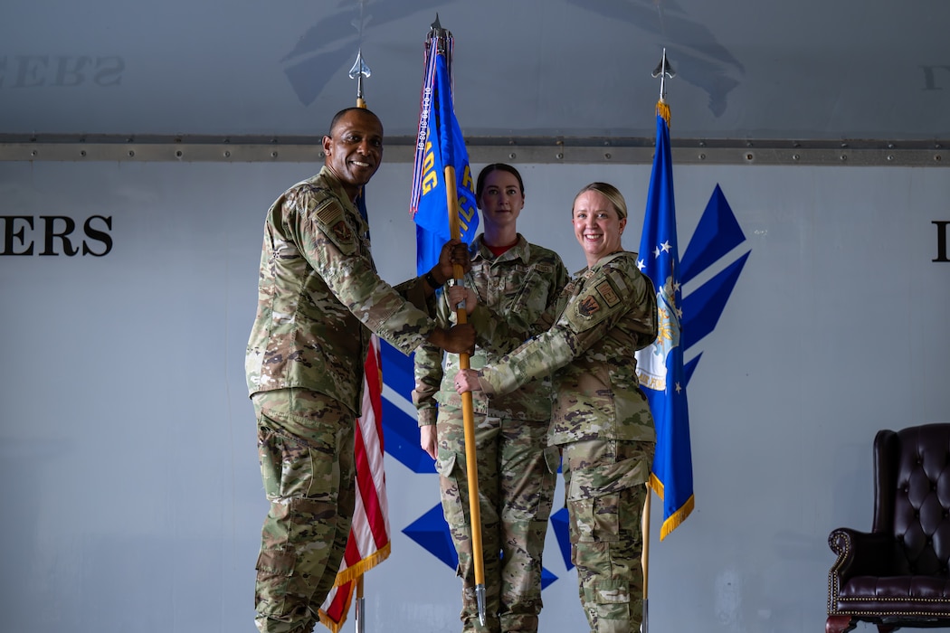 Person recieves guidon from another person.