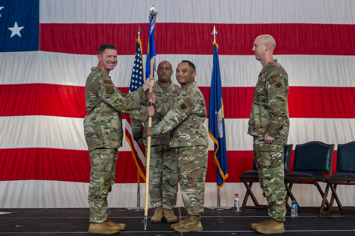 A person passing a guidon to another person