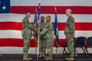 A person passing a guidon to another person