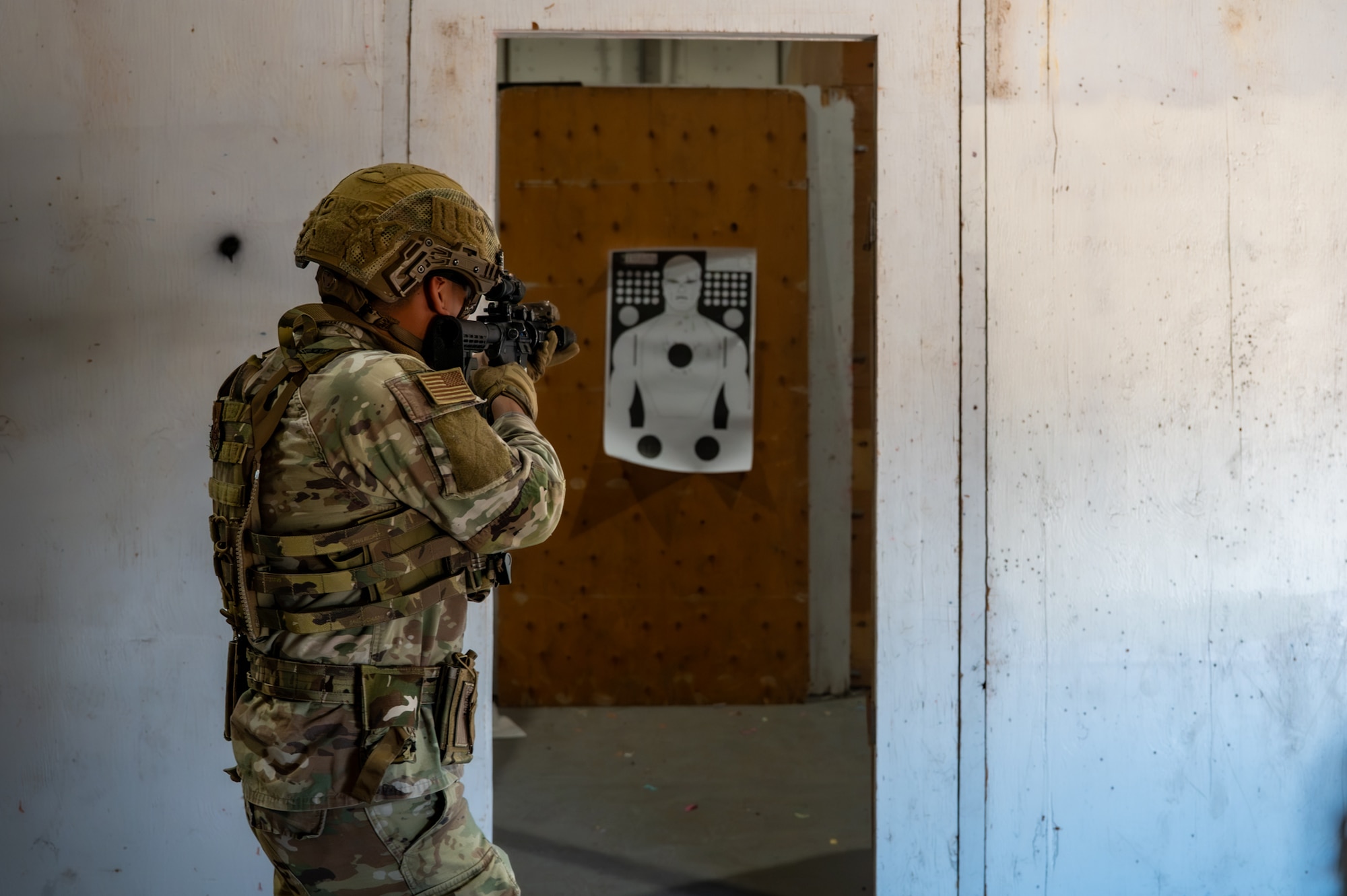 A uniformed man shoots a rifle.