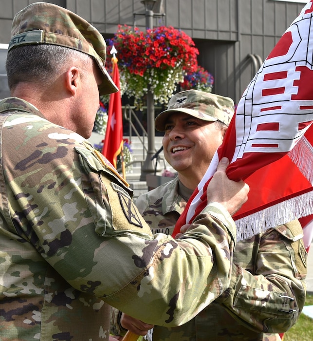 Col. Victor Trujillo II accepts the guidon from Brig. Gen. Joseph Goetz, commanding general of the USACE Pacific Ocean Division, during a change of command ceremony at the Alaska District Headquarters building on Joint Base Elmendorf-Richardson.