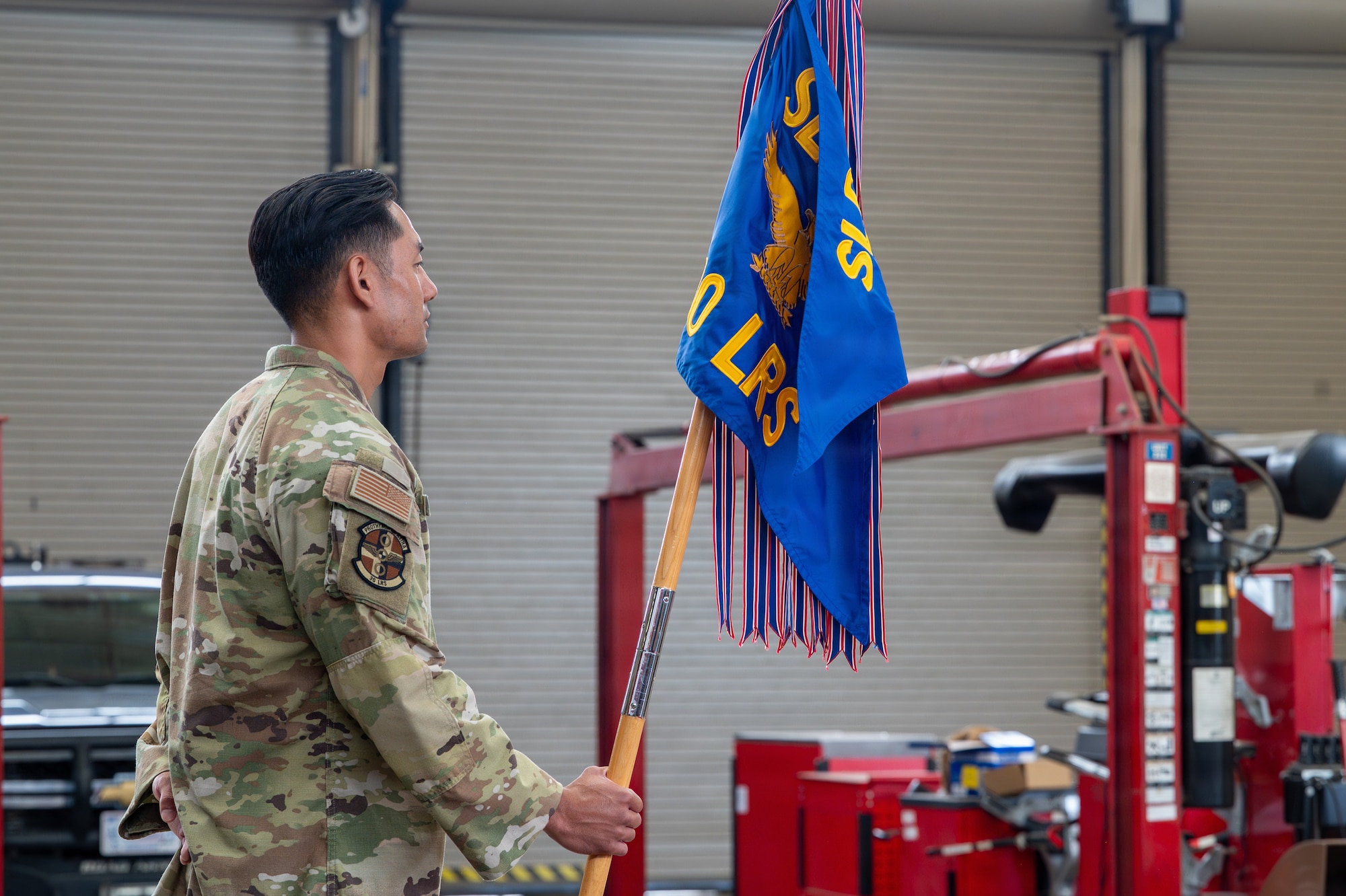 A person stands and holds a flag
