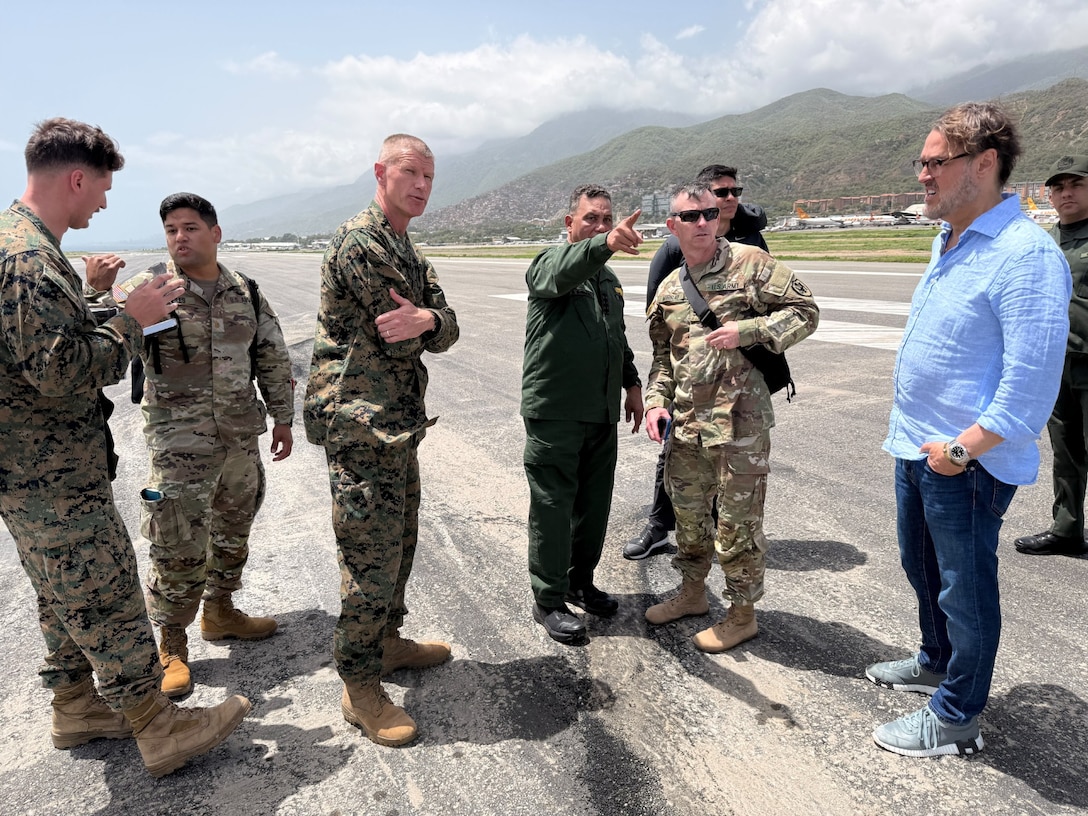 Men in military uniforms talk to one another.