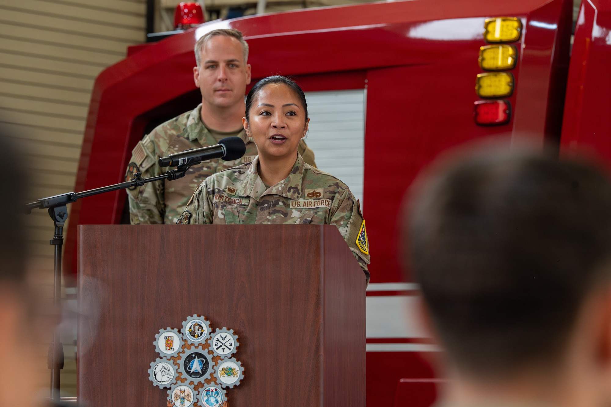 A person stands and speaks behind a podium