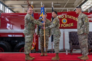 Two people stand and hold a flag on a stage