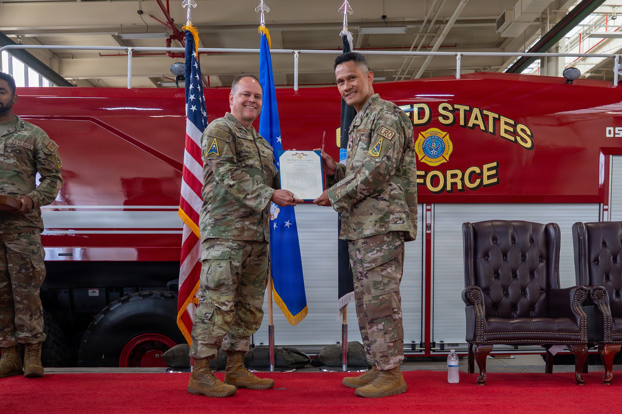 Two people hold a certificate and stand on a lift