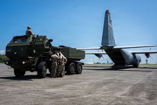 A military vehicle prepares to back into an aircraft
