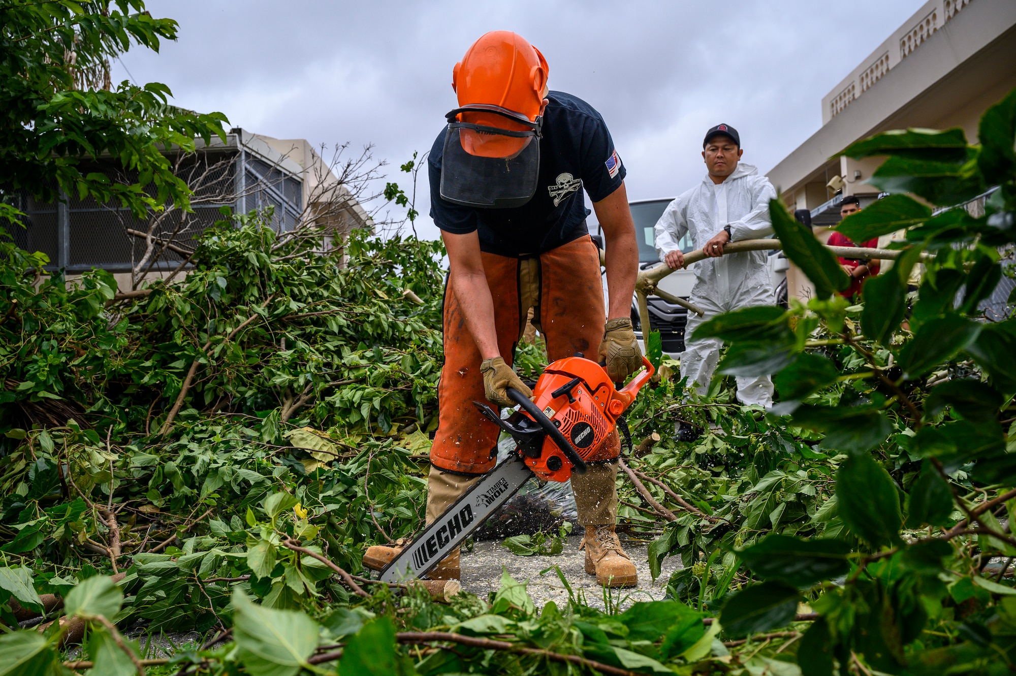 A U.S. Air Force Airman assigned to the 18th Civil Engineer Group cuts fallen branches during a volunteer cleanup project at Misato Children’s Home in Okinawa, Japan, June 12, 2026. Airmen worked alongside community members to remove storm debris and improve the grounds surrounding the facility. (U.S. Air Force photo by Airman 1st Class Francisco Huerta)