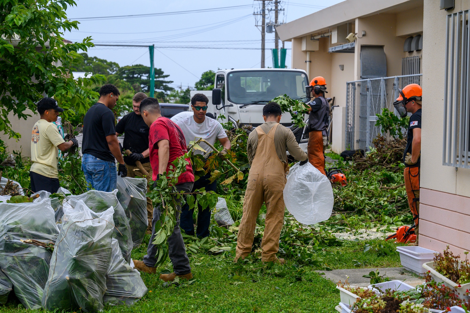 U.S. Air Force Airmen assigned to the 18th Civil Engineer Group clear overgrown vegetation during a volunteer cleanup project at Misato Children’s Home in Okinawa, Japan, June 12, 2026. The event, organized by the Kadena Top III, helped improve the safety and appearance of the facility while strengthening relationships between Kadena Air Base and the local community. (U.S. Air Force photo by Airman 1st Class Francisco Huerta)