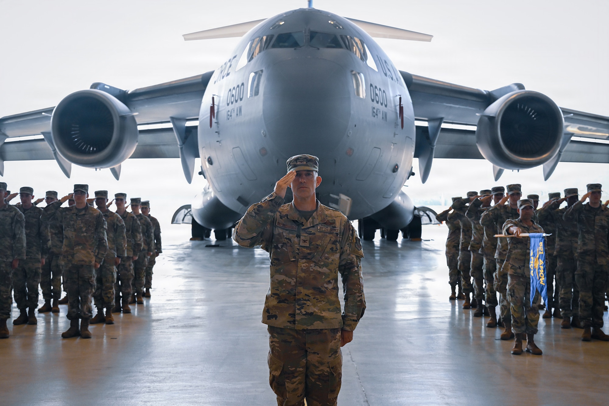 521 AMOW Airmen salute during a change in command.