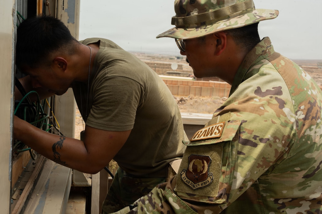 U.S. Air Force Senior Airman Physa Muon, 776th Expeditionary Air Base Squadron radar, airfield, and weather systems technician, left, and U.S. Air Force Staff Sgt. Jeremy Atienza, 776th EABS RAWS technician, right, performs diagnostic checks on a high-frequency radio system at Chabelley Airfield, Djibouti, May 19, 2026. RAWS specialists conduct routine maintenance to ensure mission-critical communication channels remain operational for airfield safety. (U.S. Air Force photo by Senior Airman Luis Gomez)