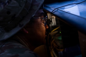U.S. Air Force Staff Sgt. Jeremy Atienza, 776th Expeditionary Air Base Squadron radar, airfield, and weather systems technician focuses intently while performing maintenance inside an equipment cabinet at Chabelley Airfield, Djibouti, May 19, 2026. RAWS technicians conduct routine maintenance to ensure mission-critical communication channels remain operational for airfield safety. (U.S. Air Force photo by Senior Airman Luis Gomez)