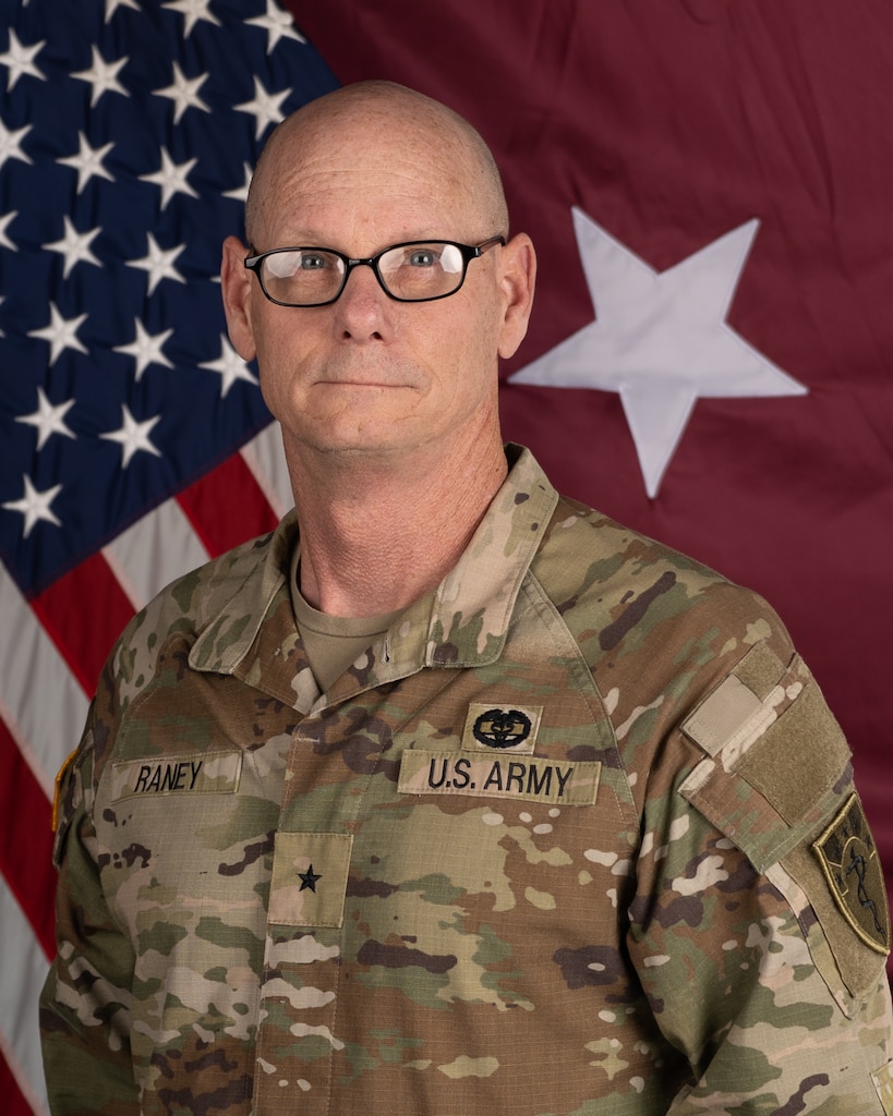 Soldier in front of flag.