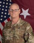 Soldier in front of flag.
