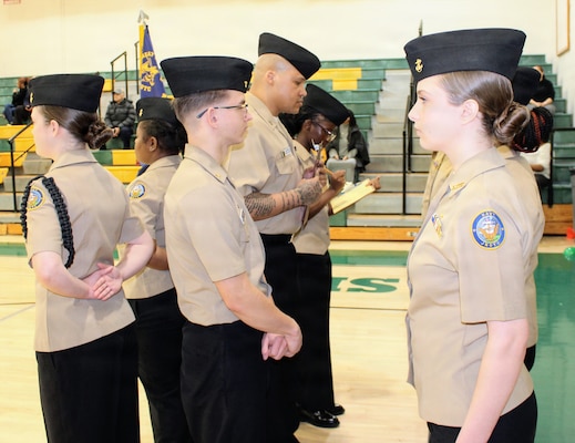 Hospital Corpsman 1st Class Antonio Armenteros, assigned to Navy Medicine Readiness and Training Command (NMRTC) Patuxent River, inspects a Navy Junior Reserve Officers Training Corps (NJROTC) cadet during the Annual Military Inspection (AMI) at Great Mills High School. Armenteros served as a guest inspector for the event, evaluating cadets on military bearing, uniform appearance and general knowledge. The command's participation highlights its commitment to community outreach and developing the next generation of leaders.