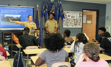 Chief Petty Officer Amber Ronquille, assigned to Navy Medicine Readiness and Training Command (NMRTC) Patuxent River, discusses the command's detachment at Indian Head during a presentation to Air Force Junior Reserve Officers Training Corps (AFJROTC) cadets at Chopticon High School, as Hospital Corpsman 2nd Class Ifeoluwapo Olayemi looks on. The engagement was part of a spring semester outreach initiative focused on leadership, professional development, and showcasing the diverse roles within Navy Medicine to the next generation of potential service members.
