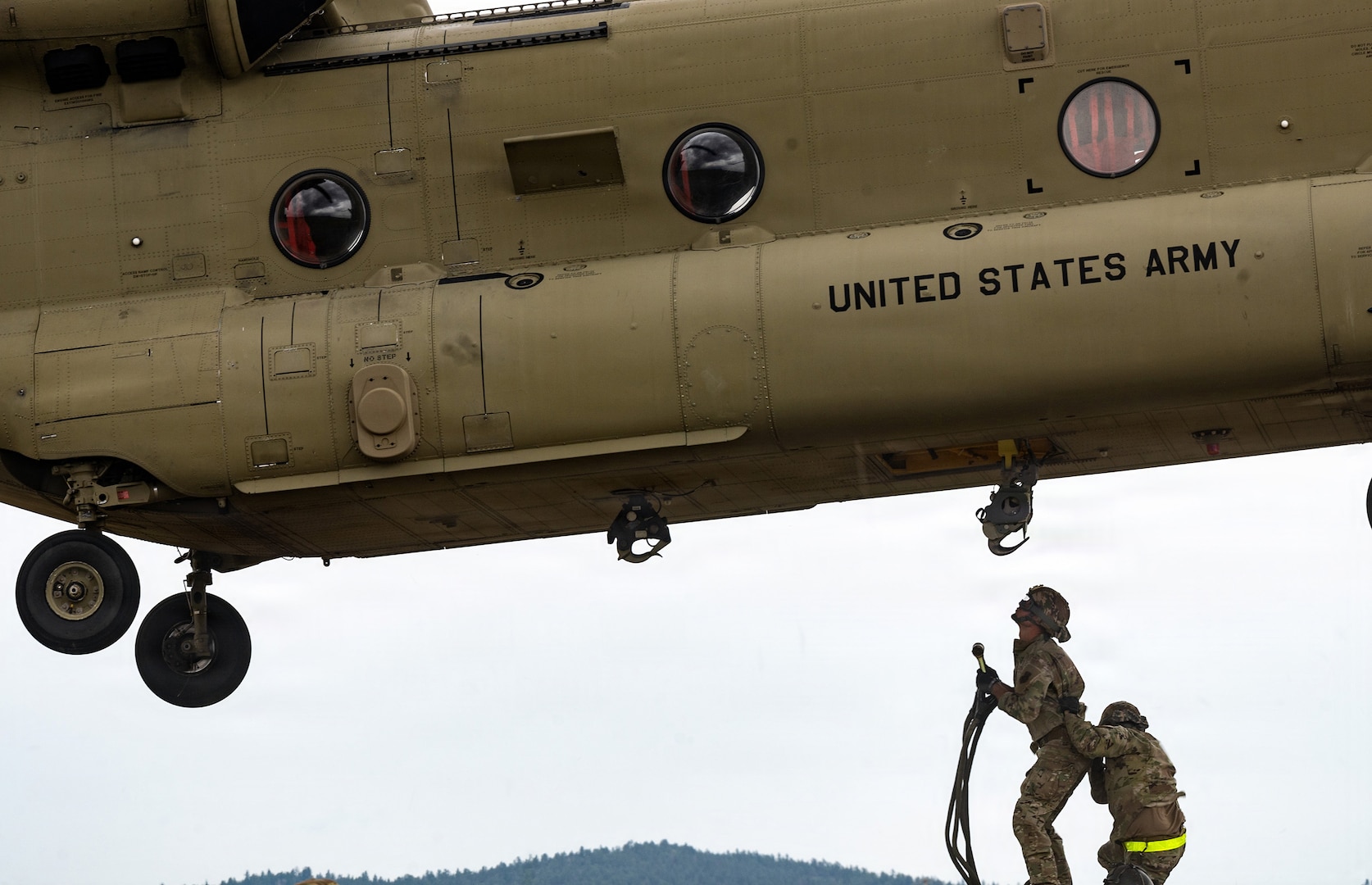 Airmen assigned to the 219th Red Horse Squadron prepare to attach an MEP-806 power generator to a CH-47 Chinook helicopter assigned to the 1st Battalion, 189th Aviation Regiment (General Support Aviation) for sling load operations during a joint field training exercise at Fort Harrison, Montana, June 26, 2026.