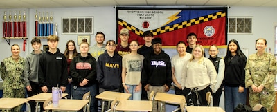 Chief Petty Officer Amanda Ellis, left, assigned to Navy Medicine Readiness and Training Command (NMRTC) Patuxent River, and retired Master Sgt. Kim Hoh, right, an Aerospace Science Instructor with the Chopticon High School Air Force Junior Reserve Officers Training Corps (AFJROTC), pose for a photo with cadets following a presentation. Ellis visited the AFJROTC classes to share her experiences and discuss career opportunities within Navy Medicine.