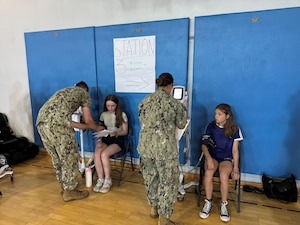 Lt. Vanessa Bernales and Hospital Corpsman 3rd Class Benjamin Mason conduct blood pressure screenings for Department of War Education Activity (DoWEA) student athletes during a sports physical rodeo at David Glasgow Farragut Middle High School, Naval Station Rota, Spain, June 02, 2026. During the event, U.S. Naval Hospital Rota staff completed more than 169 sports physicals, improving access to care for military families and helping students meet participation requirements for the 2026–2027 school year. (U.S. Navy photo by Lt. Marlena Irizarry)