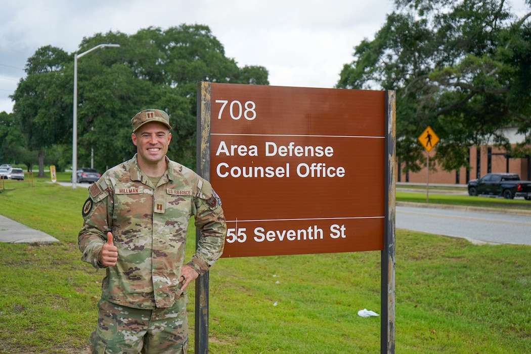 Photo shows man in uniform standing in front of ADC sign giving a "thumbs up" gesture.