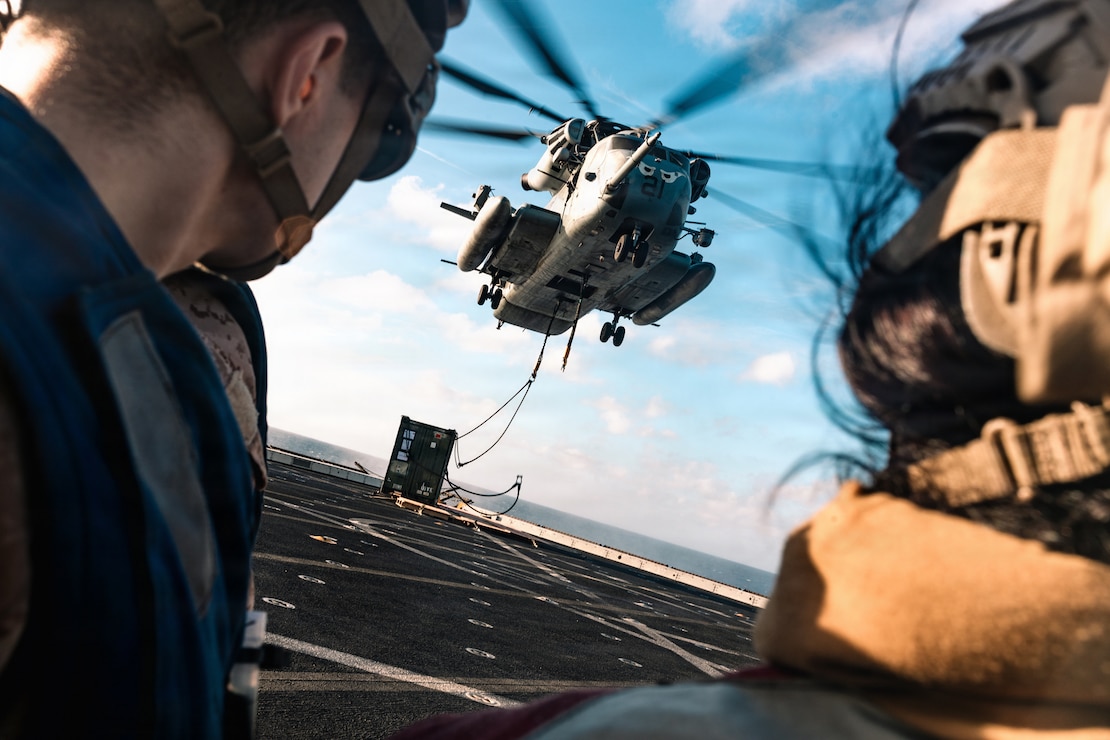 A CH-53E Super Stallion with Marine Medium Tiltrotor Squadron (VMM) 163 (Reinforced), 11th Marine Expeditionary Unit, places a cargo container on the flight deck of San Antonio-class amphibious transport dock ship USS Portland (LPD 27) during external lift training in the Indian Ocean, June 24, 2026. The 11th MEU, embarked aboard the Boxer Amphibious Ready Group, is a persistent, combat credible force contributing to deterrence and crisis response in the U.S. 7th Fleet area of operations. U.S. 7th Fleet, the U.S. Navy’s largest forward-deployed numbered fleet, routinely interacts and operates with allies and partners to preserve a free and open Indo-Pacific. (U.S. Marine Corps photo by Lance Cpl. Luke Rodriguez)