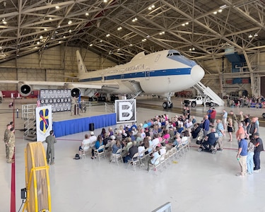 A crowd sits in front of an E-4B