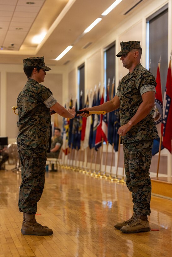 U.S. Marine Corps Lt. Col. Glenn Berdela Jr., right, commanding officer, 2nd Network Battalion, Marine Corps Cyberspace Operations Group, passes the sword of office to Sgt. Maj. Erin E. Carpenter, oncoming senior enlisted leader for 2nd Network Bn, MCCOG, during a relief and appointment ceremony at Marine Corps Base Camp Lejeune, North Carolina, June 2, 2026. 2nd Network Bn held the ceremony to mark the transition of its senior enlisted leadership, signifying the transfer of all responsibilities and authorities between the outgoing and incoming sergeants major. (U.S. Marine Corps Photo by Cpl. Jessica J. Mazzamuto)
