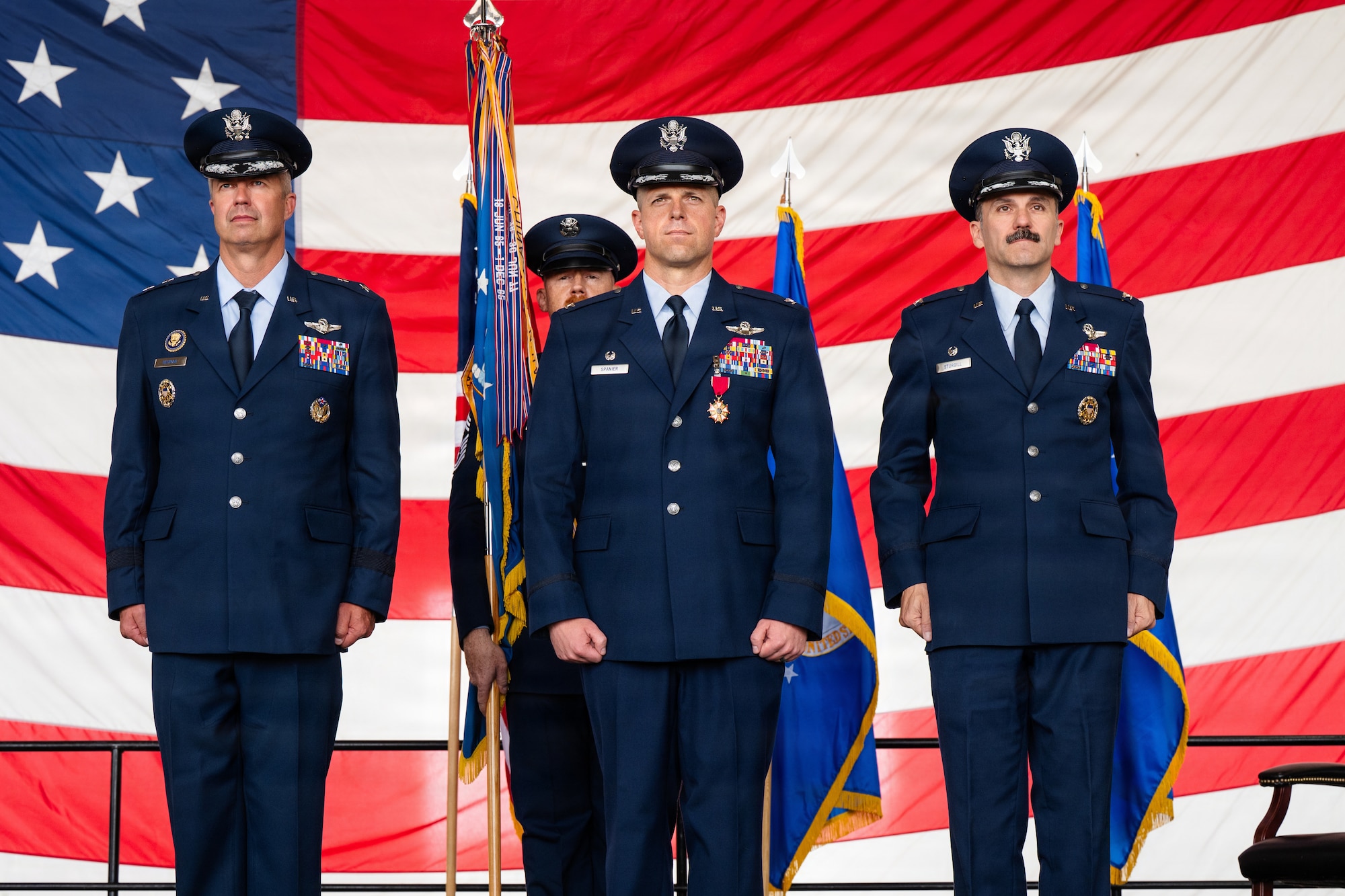Airmen stand on stage during a formal Change of Command Ceremony