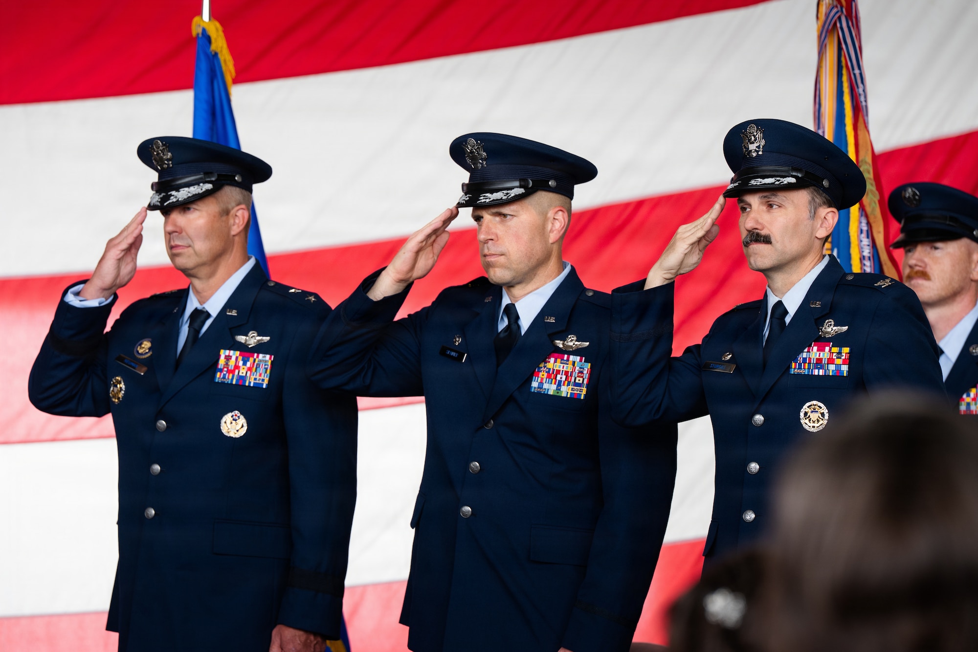 Airmen stand on stage during a formal Change of Command Ceremony