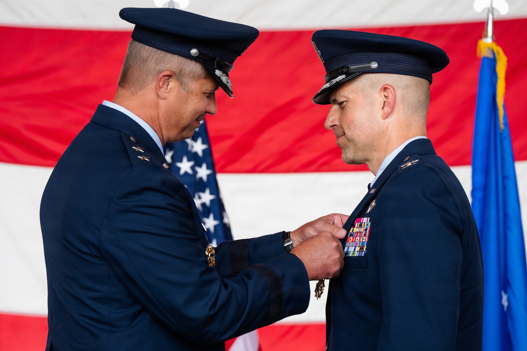Airmen stand on stage during a formal Change of Command Ceremony