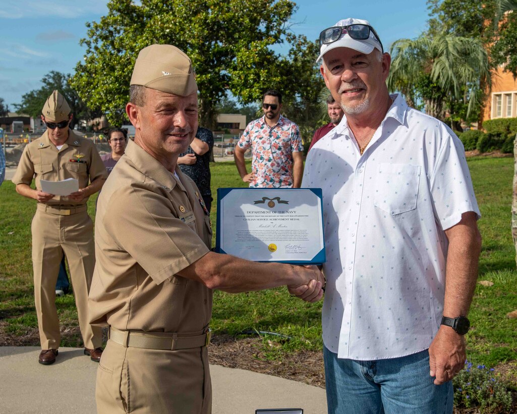 (left) Capt. Paul Stence, Jr., Naval Surface Warfare Center Panama City Division (NSWC PCD) commanding officer, presents Mitchell Martin, NSWC PCD LCAC operator and technician, with the Department of the Navy Civilian Service Achievement Medal, June 12. His actions enabled the deployment of the full complement of four LCACs to the fleet. (U.S. Navy photo by Eddie Green)