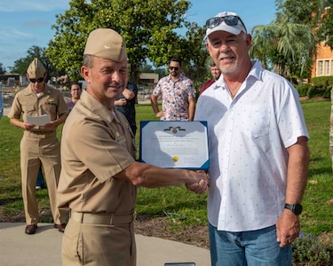 (left) Capt. Paul Stence, Jr., Naval Surface Warfare Center Panama City Division (NSWC PCD) commanding officer, presents Mitchell Martin, NSWC PCD LCAC operator and technician, with the Department of the Navy Civilian Service Achievement Medal, June 12. His actions enabled the deployment of the full complement of four LCACs to the fleet. (U.S. Navy photo by Eddie Green)