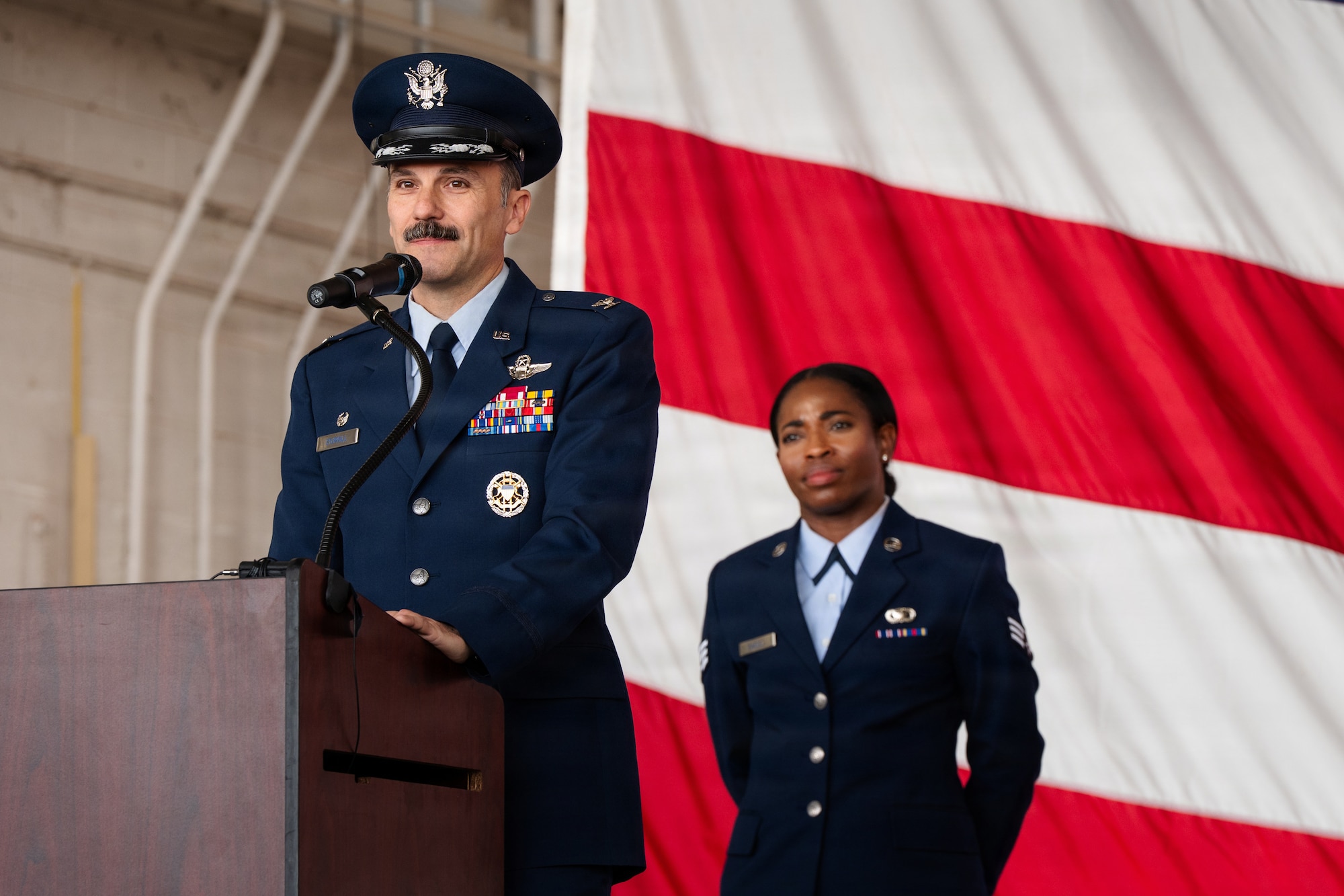 Airmen stand on stage during a formal Change of Command Ceremony