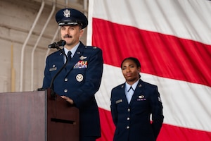 Airmen stand on stage during a formal Change of Command Ceremony