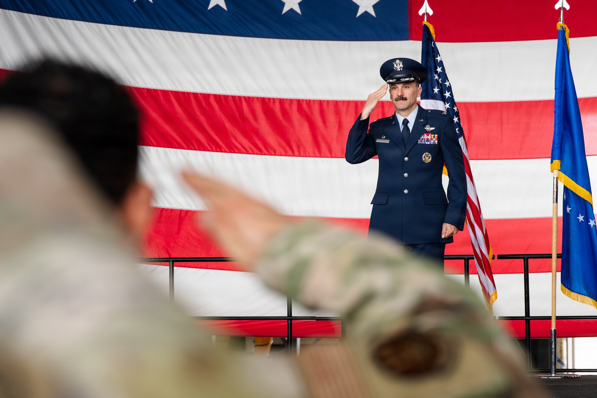 Airmen stand on stage during a formal Change of Command Ceremony
