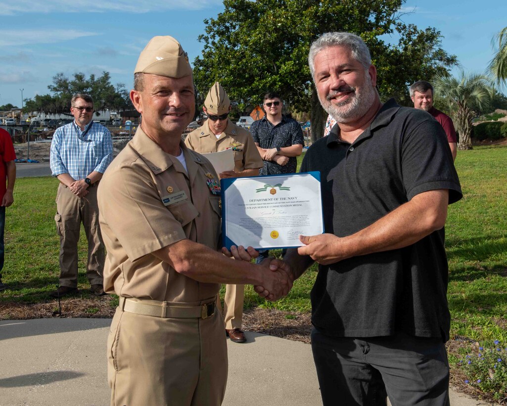 (left) Capt. Paul Stence, Jr., Naval Surface Warfare Center Panama City Division (NSWC PCD) commanding officer, presents Garrett Fulton with the Department of the Navy Civilian Service Commendation Medal, June 12. As the Landing Craft Air Cushion maintenance deputy, Fulton orchestrated a compressed schedule to complete all critical repairs, upgrades, and inspections. (U.S. Navy photo by Eddie Green)