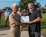 (left) Capt. Paul Stence, Jr., Naval Surface Warfare Center Panama City Division (NSWC PCD) commanding officer, presents Garrett Fulton with the Department of the Navy Civilian Service Commendation Medal, June 12. As the Landing Craft Air Cushion maintenance deputy, Fulton orchestrated a compressed schedule to complete all critical repairs, upgrades, and inspections. (U.S. Navy photo by Eddie Green)