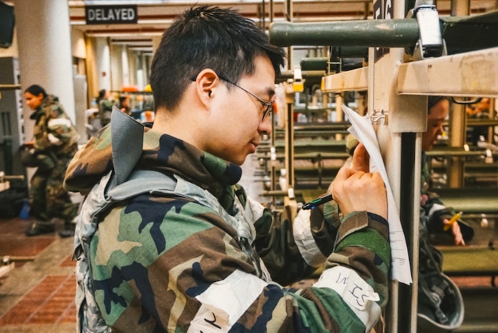 Image of an Airman writing on a piece of paper.