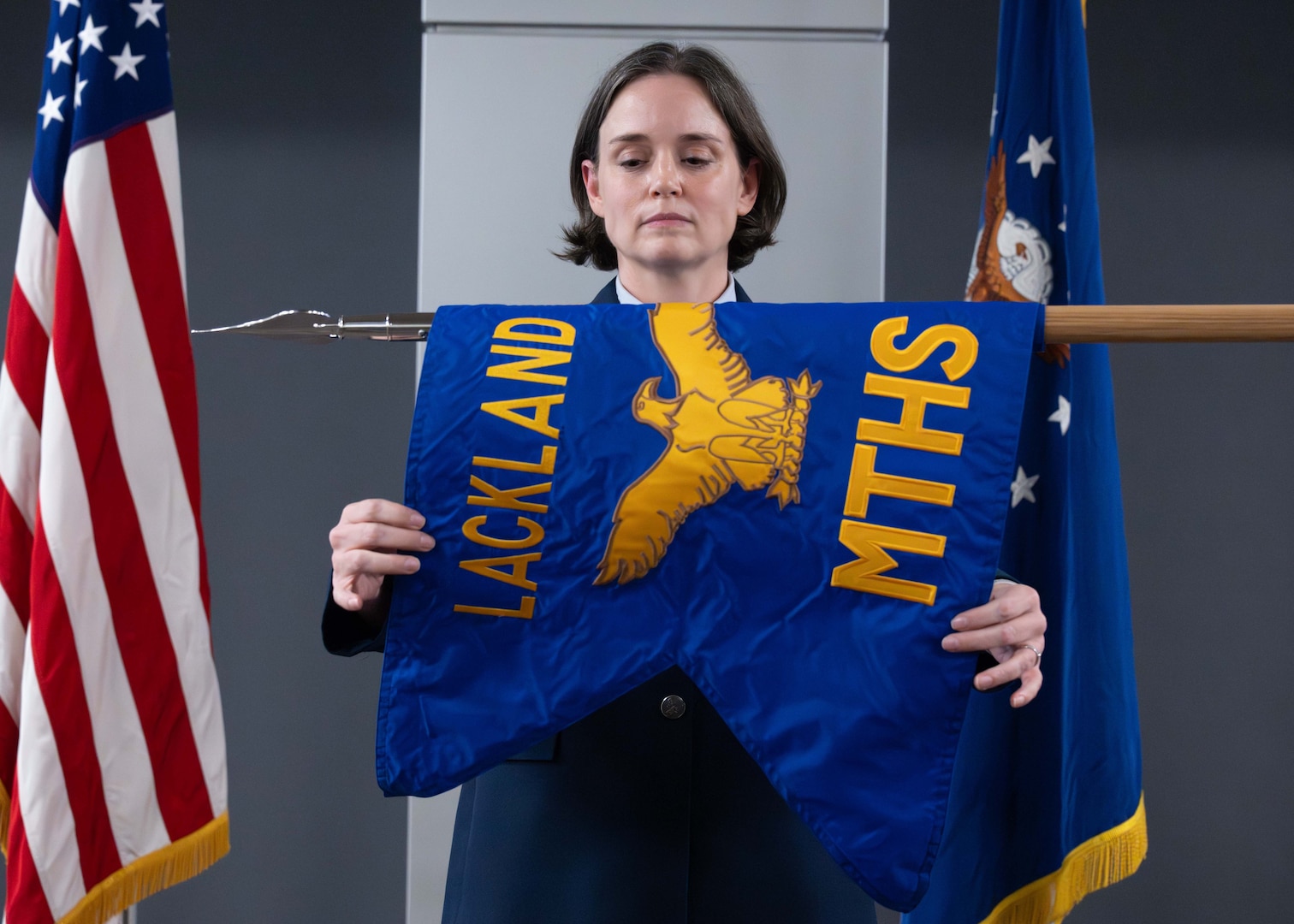 U.S. Air Force Col. Shawn Garcia, commander of the Lackland Medical Group, unfurls the newly activated Lackland Mental Health Squadron guidon during an activation ceremony at Wilford Hall Ambulatory Surgical Center, Joint Base San Antonio-Lackland, Texas, June 25, 2026.
